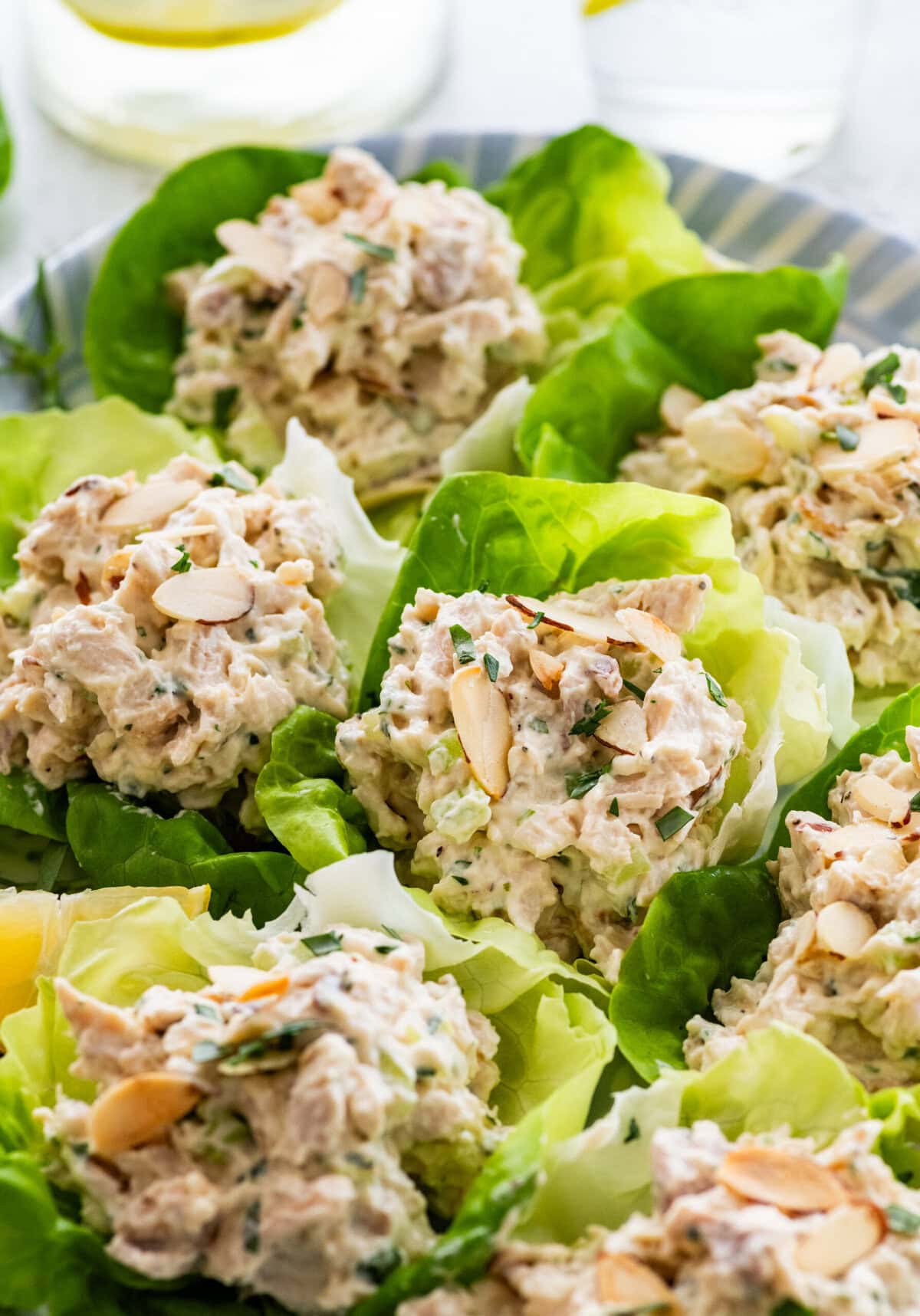 Tarragon chicken salad in lettuce cups plated on a large dish.
