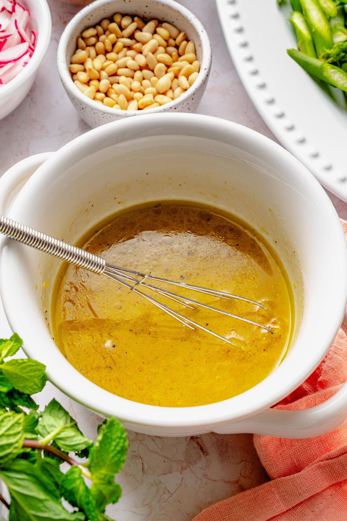 Whisked dressing in a bowl with whisk still sitting in it.