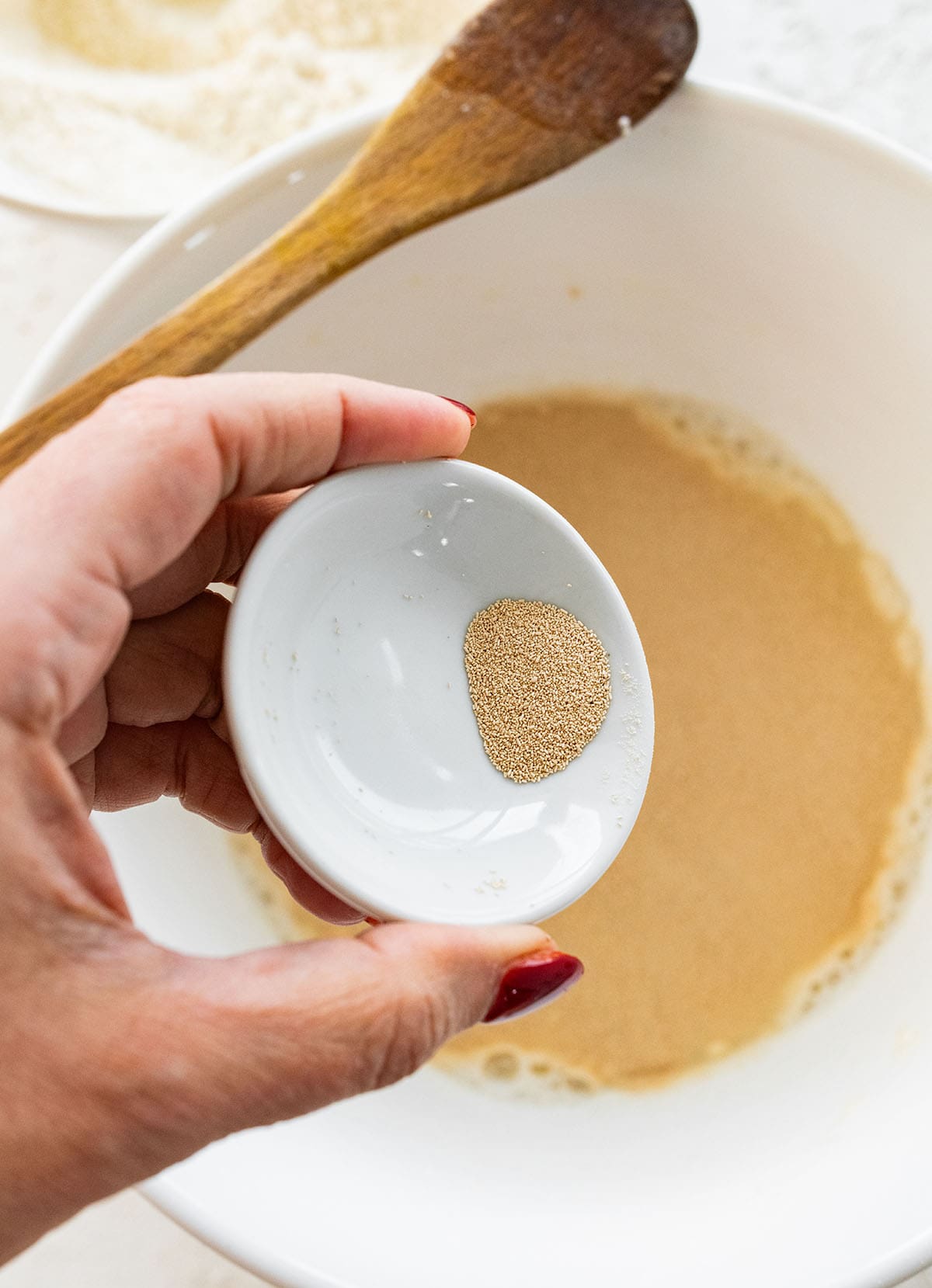 adding the yeast to the flour and water mixture.