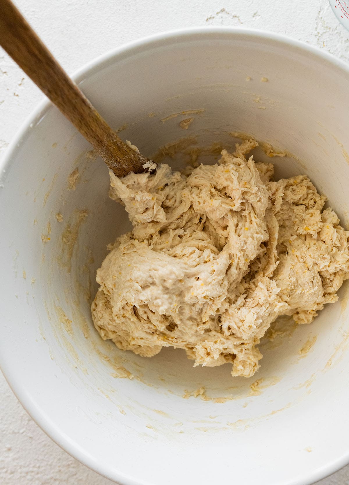 thick, shaggy dough in a bowl with a wooden spoon.
