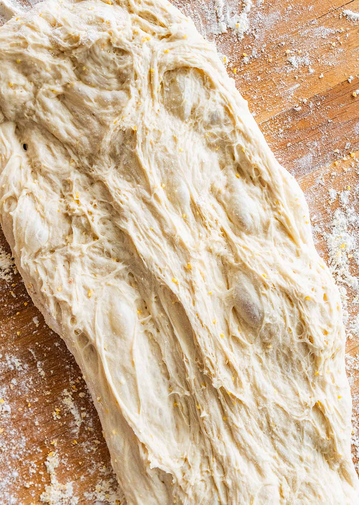 ciabatta dough in a rectangle on a floured cutting board.