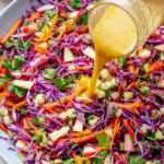 Pouring the dressing over the bowl of salad.