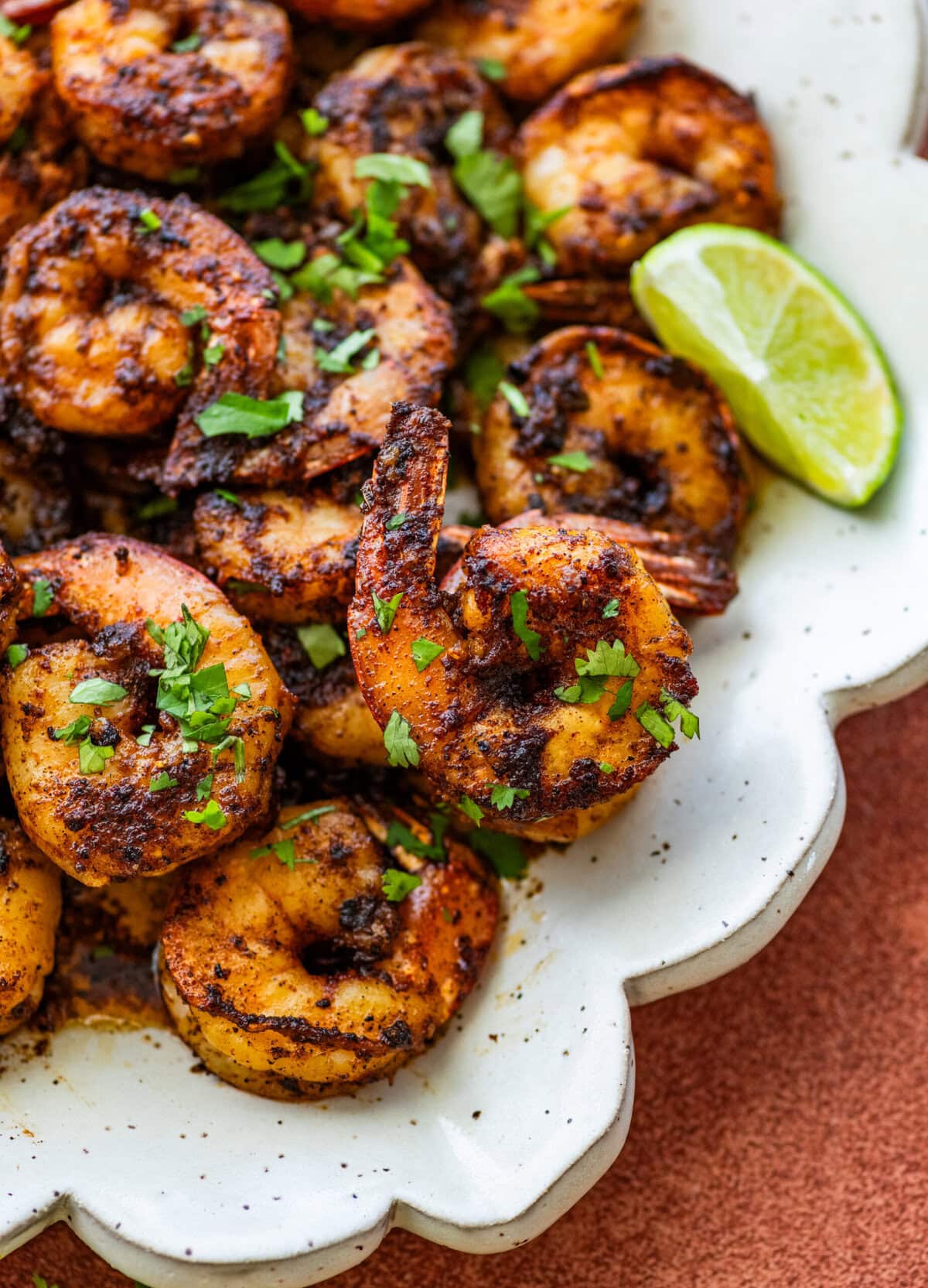 Blackened shrimp on a plate with garnish.