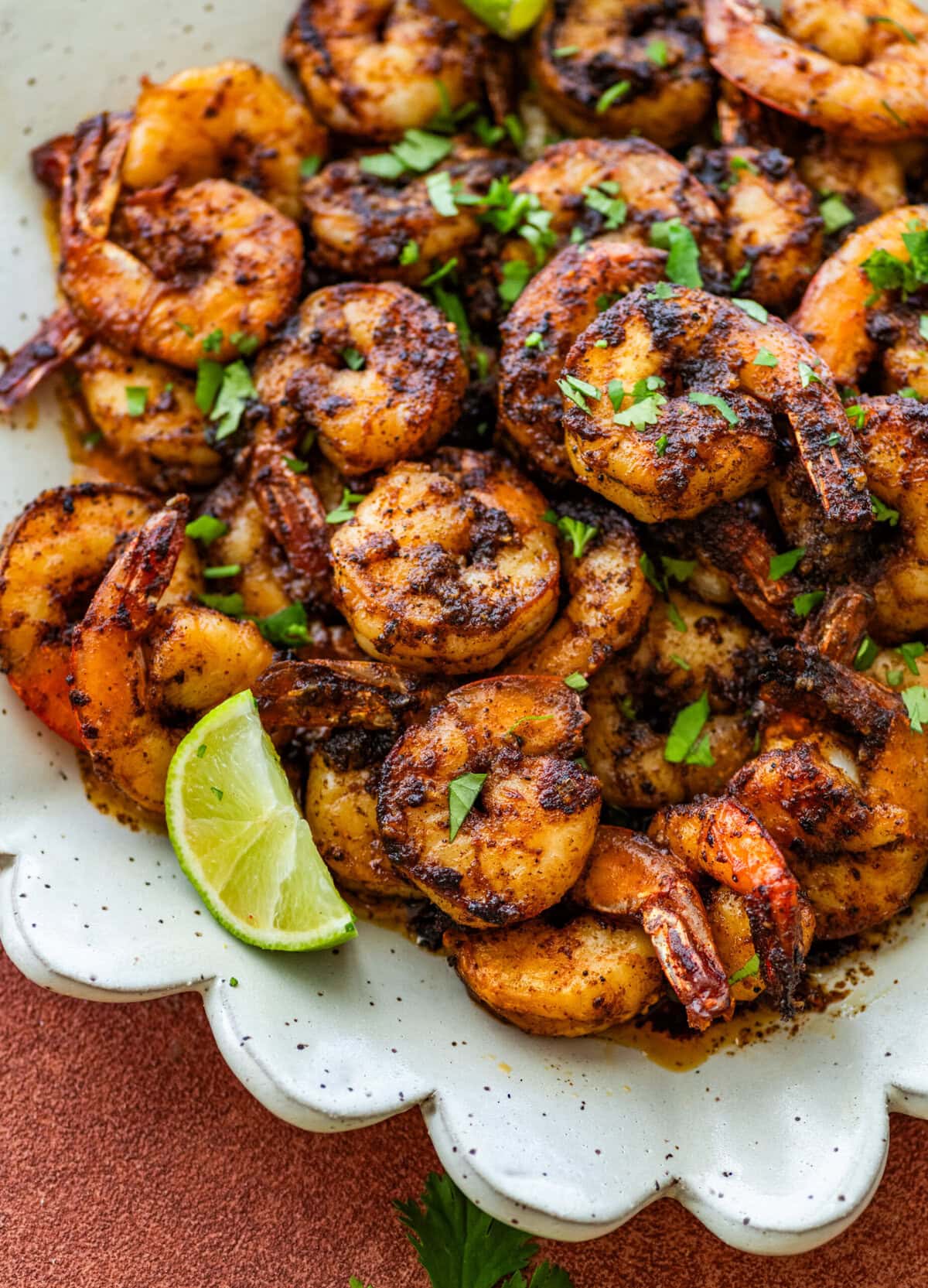 Blackened shrimp on a plate with garnish.