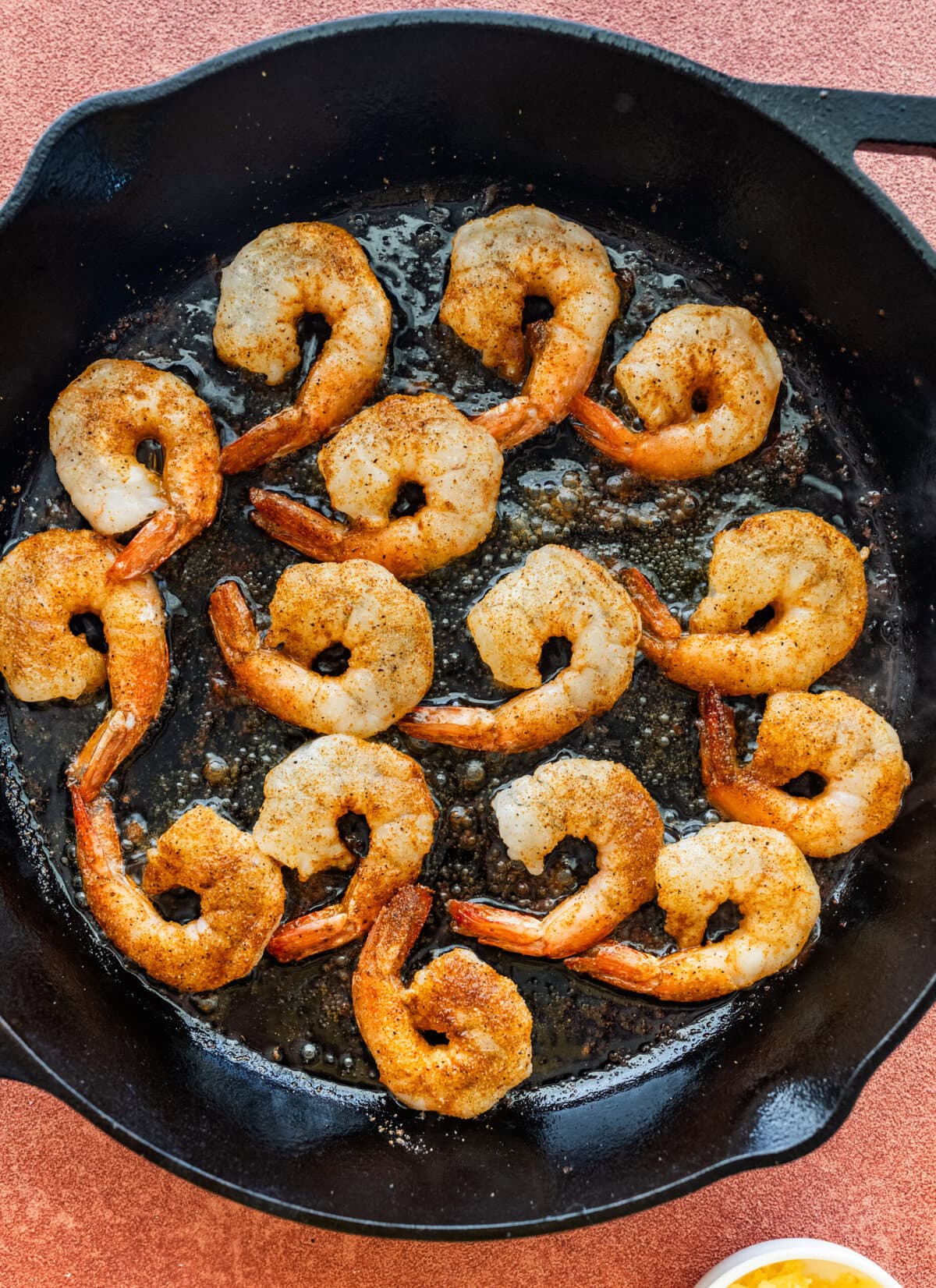 One layer of shrimp in a skillet.