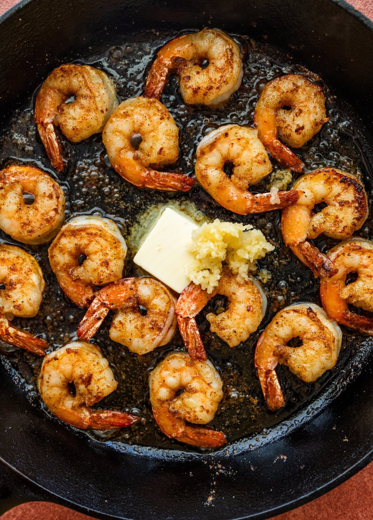 Butter and garlic added to the skillet of shrimp.