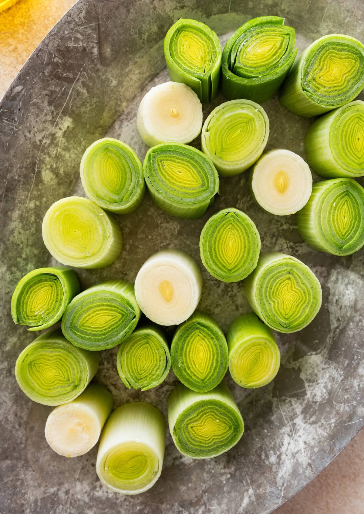 Trimmed, cleaned, and cut leeks on a cutting board.