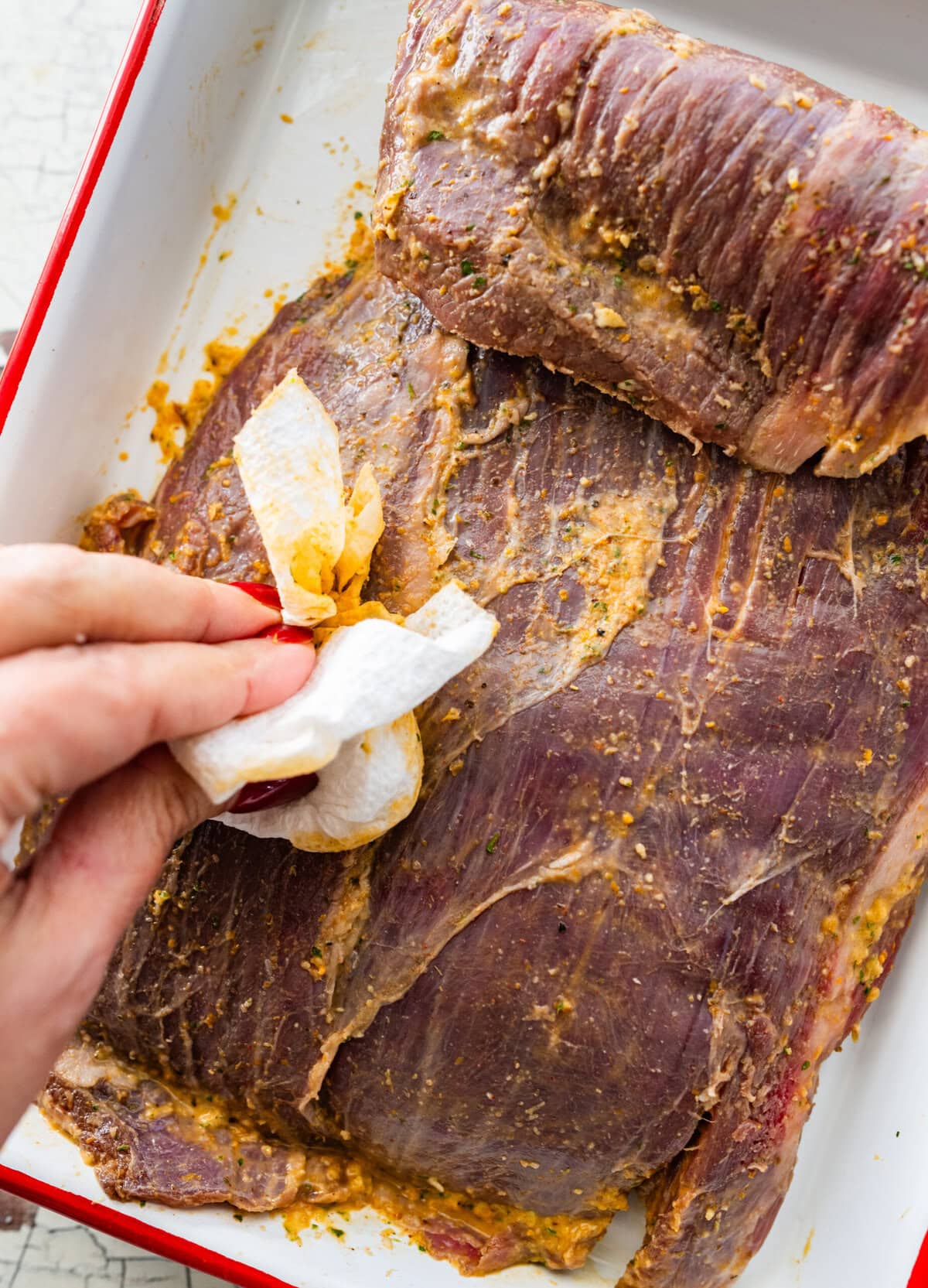 Patting steak dry with paper towels.