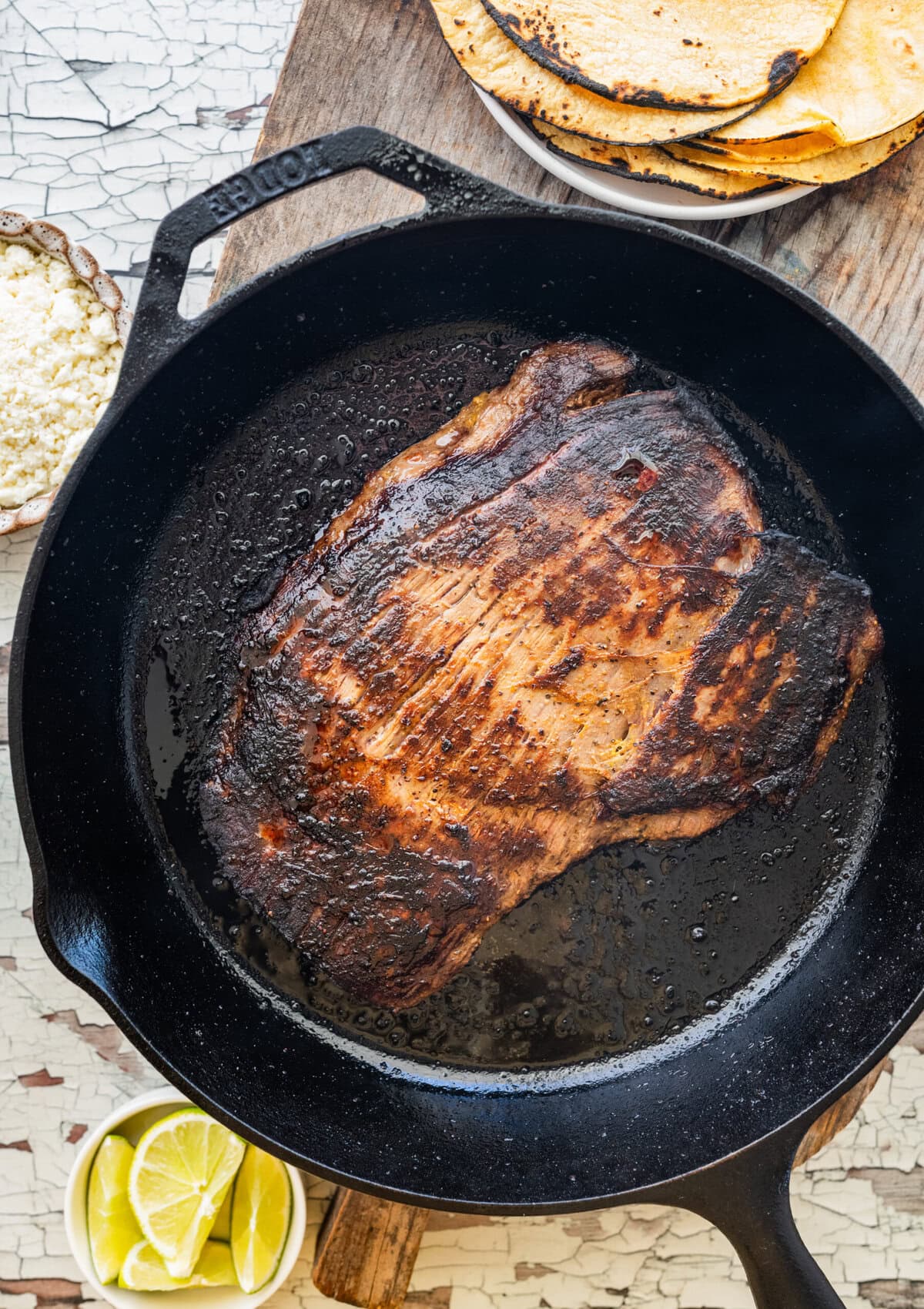 Steak in cast iron pan after flipping.