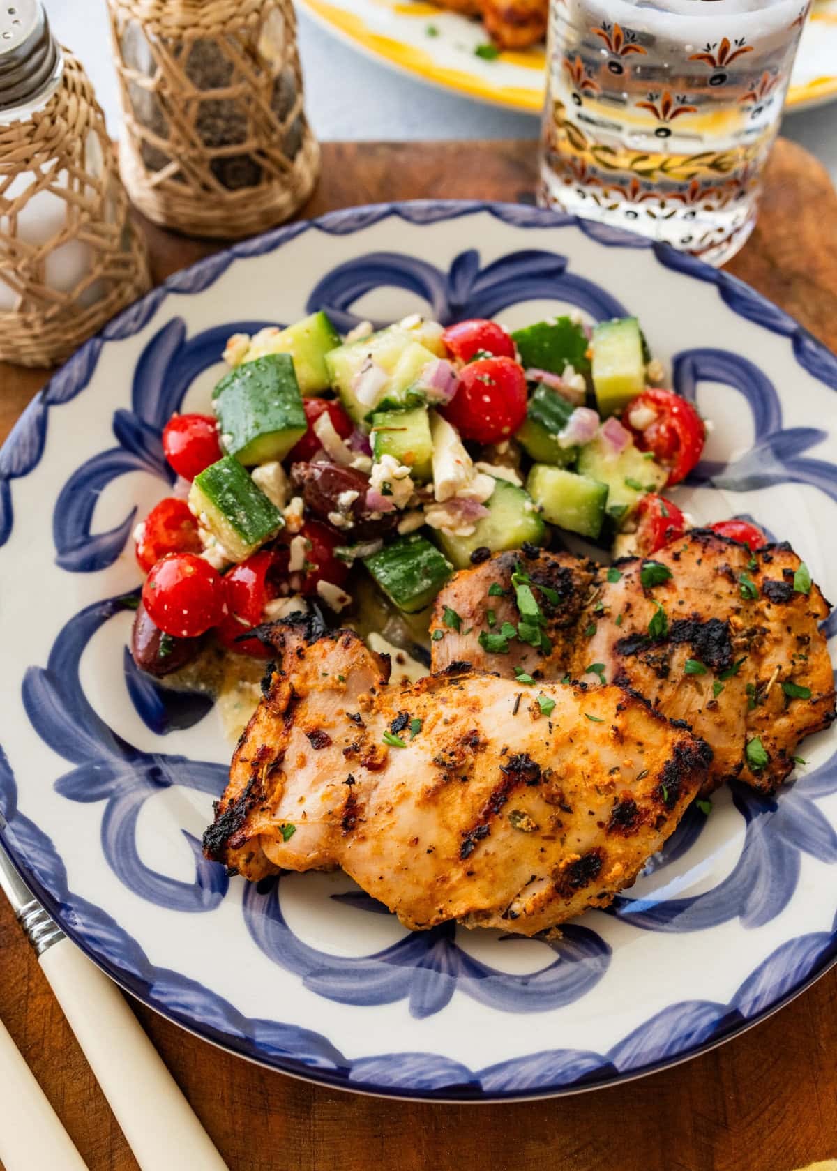 One piece of chicken on a dish plated with a side.
