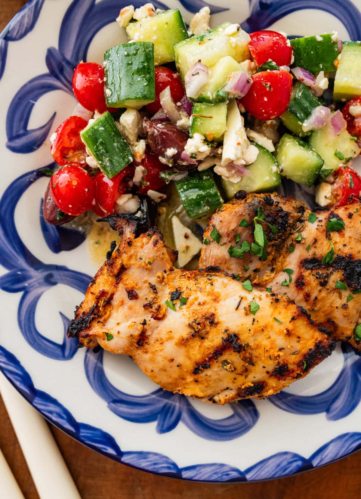 One piece of chicken on a dish plated with a side.