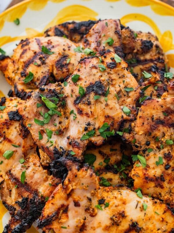 Chicken on a serving dish with garnish.