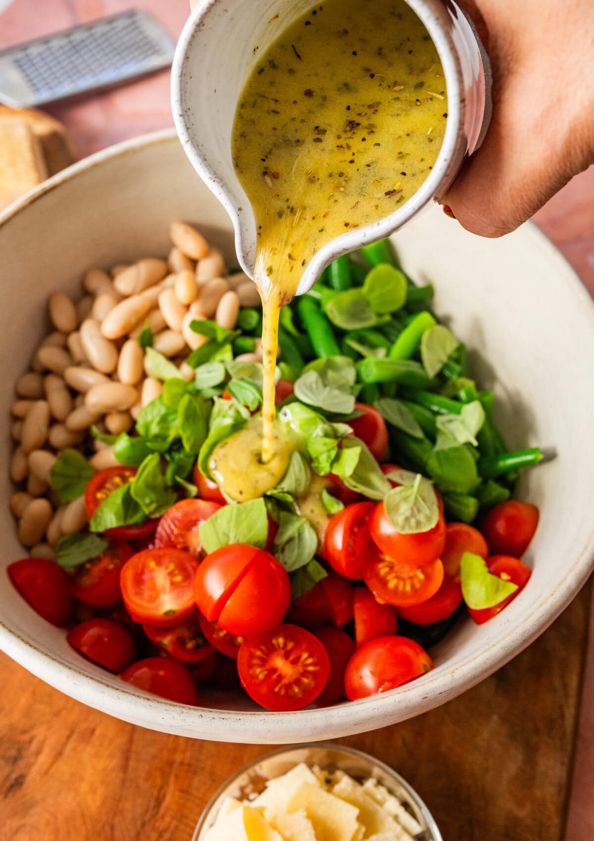 Dressing being poured over the green bean salad.