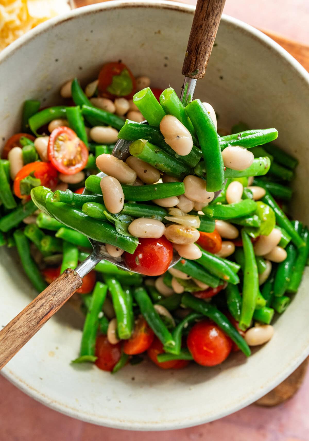 A spoon holding up a serving of the green bean salad.