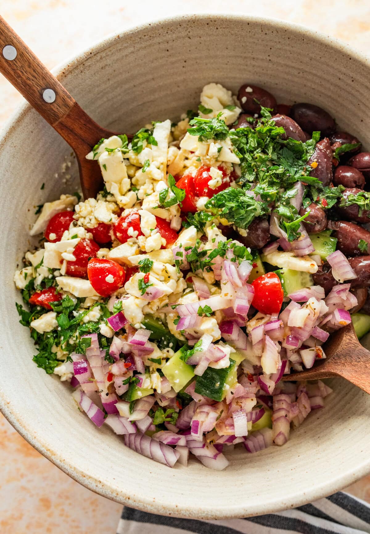 Utensils mixing the salad together.