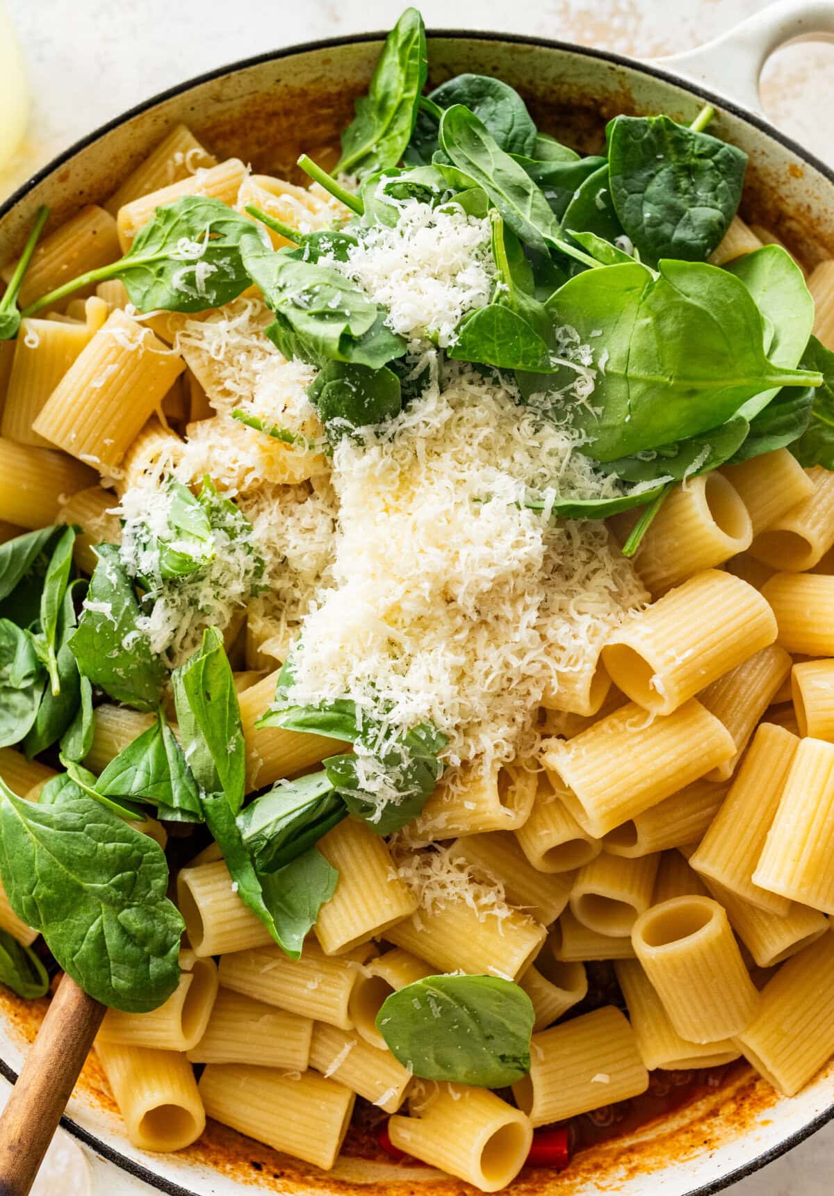 Cheese and spinach added on top of the pasta, sausage, and pepper mixture.