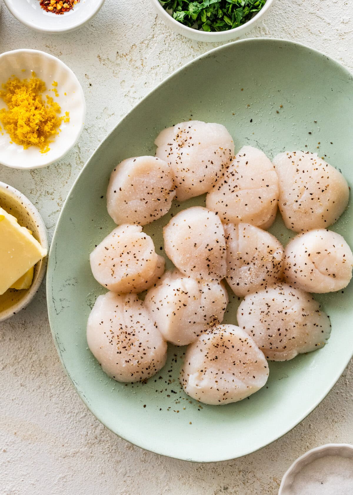 Seasoned scallops on a plate.