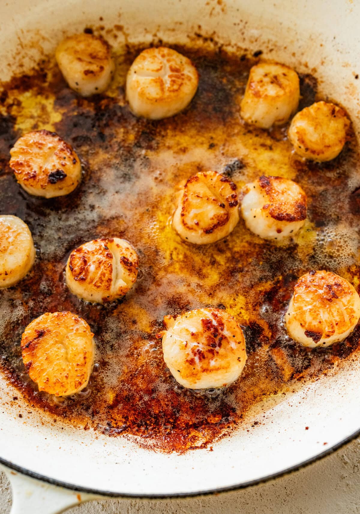 Seared scallops in a large skillet.