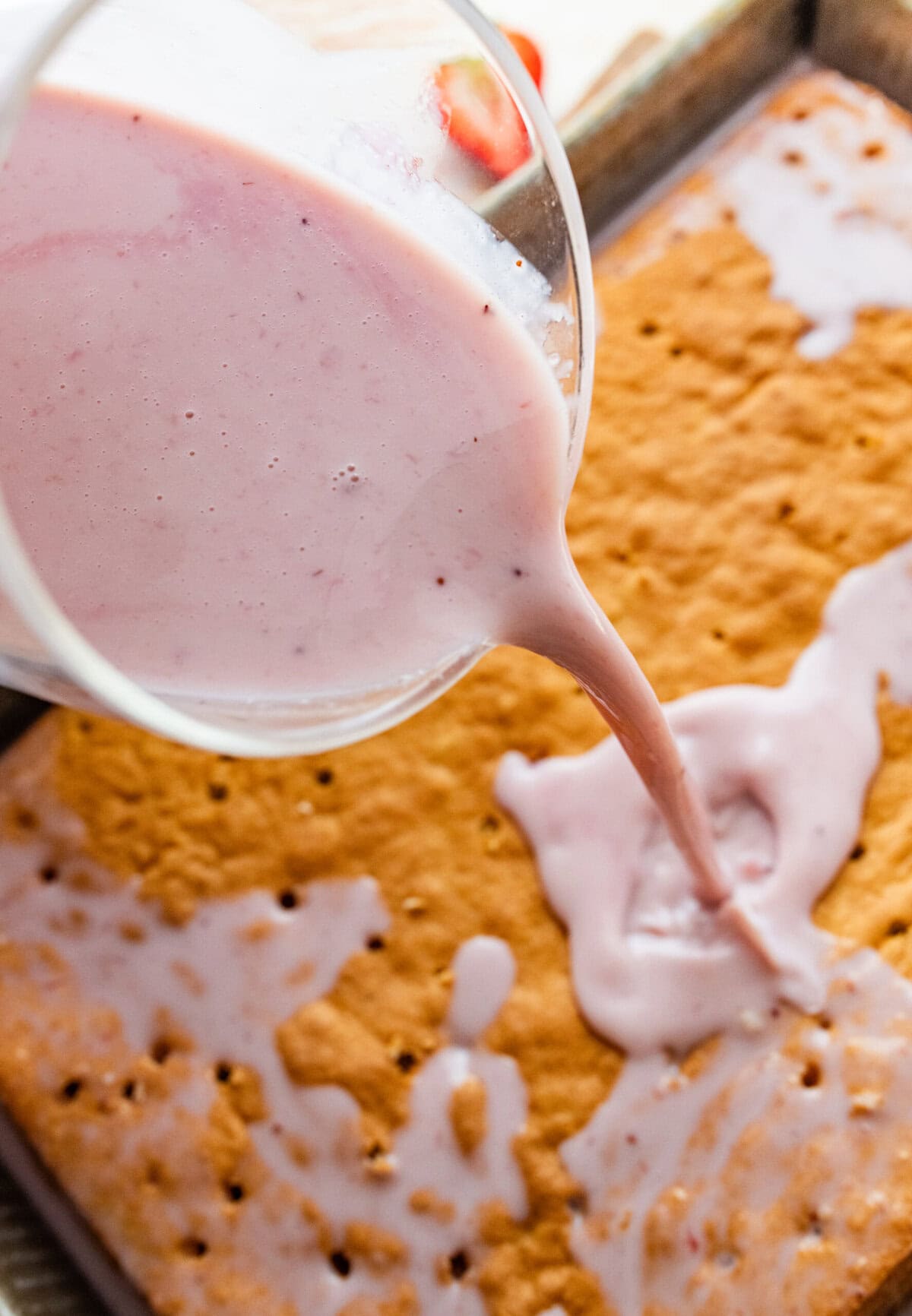 pouring milk mixture over the cooked cake.