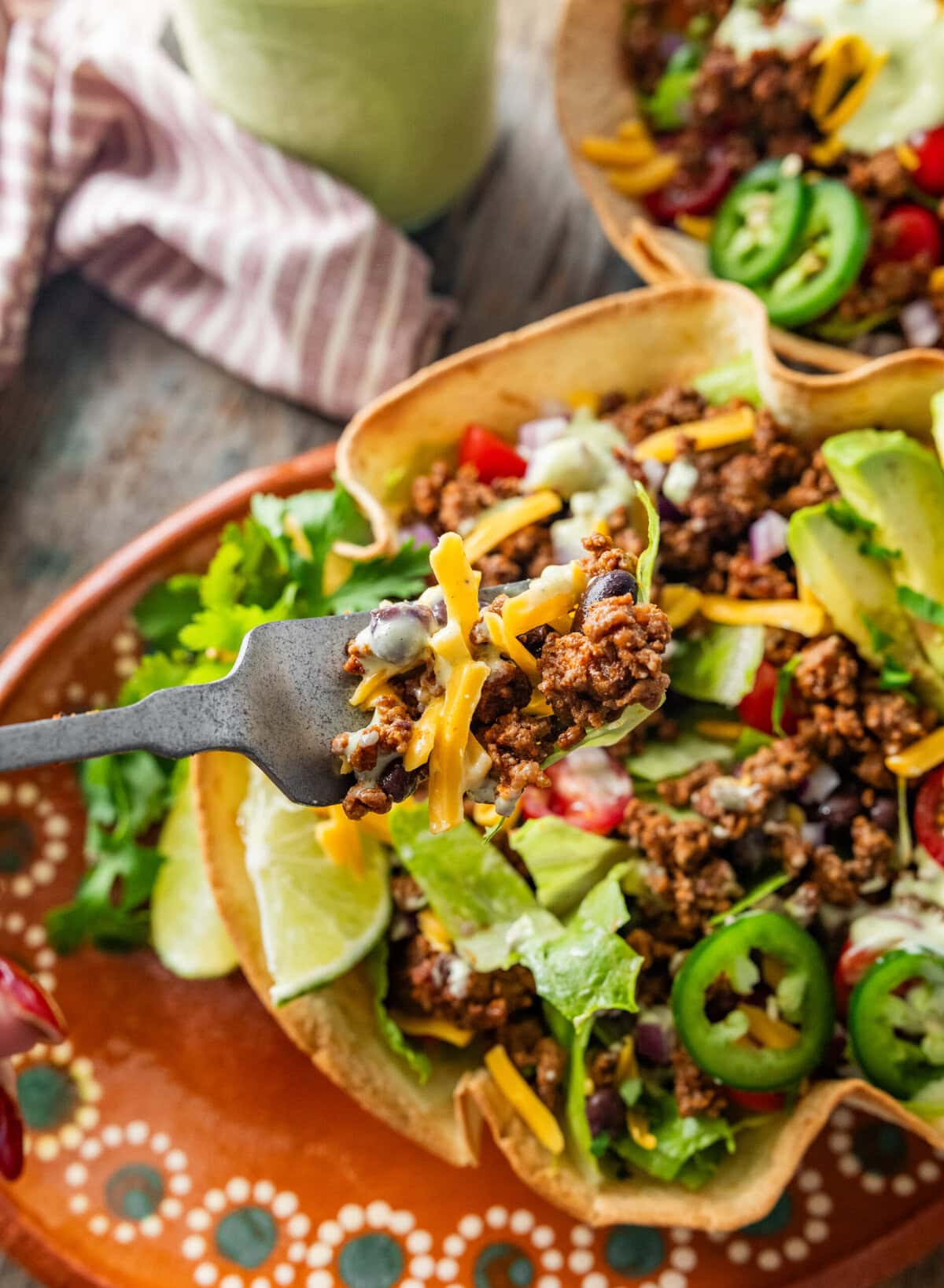 Two fully dressed taco bowls with garnish.