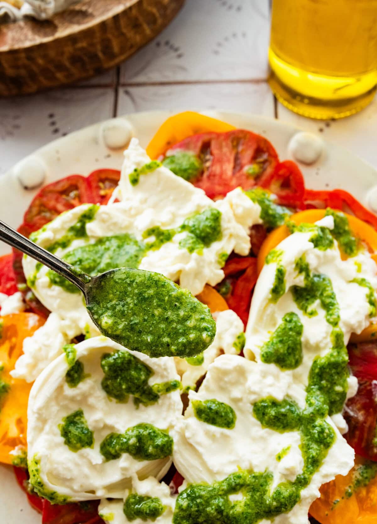 A spoon of the pesto holding over the salad.