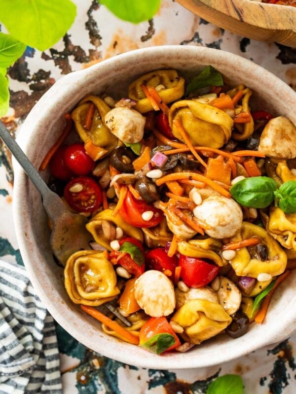 bowl of Italian tortellini pasta salad with a fork.