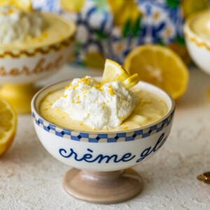 One serving of lemon mousse in a bowl with garnish and more ingredients in the background.