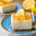 frozen lemon bar on a blue plate with a spoon.
