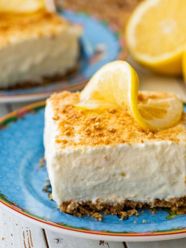 frozen lemon bar on a blue plate with a spoon.