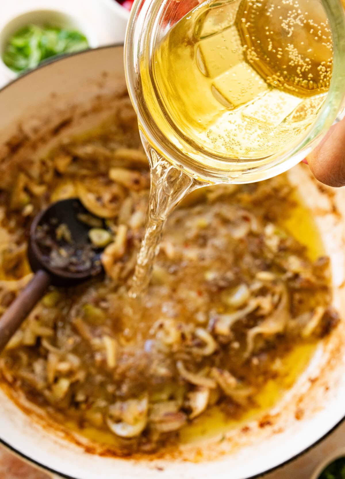 White wine being poured into the skillet.