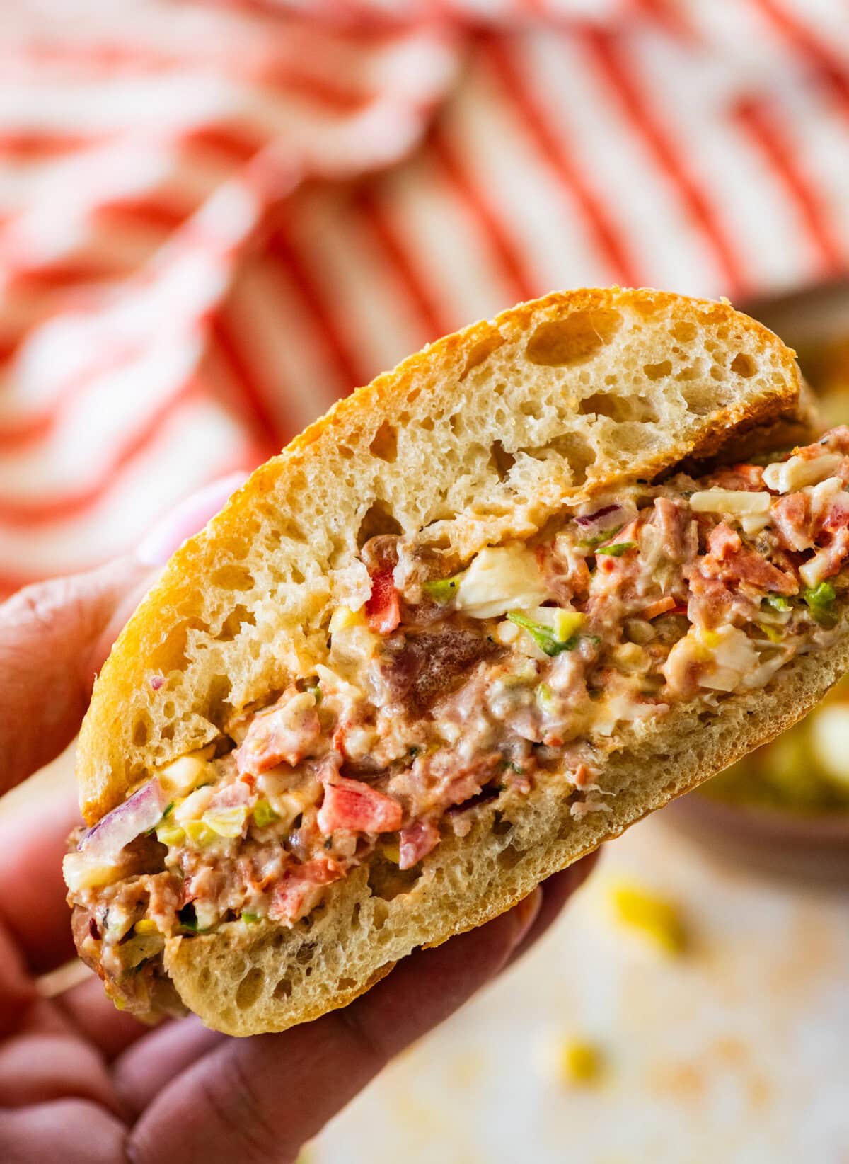 a chopped italian sandwich held by two hands to show the insides.