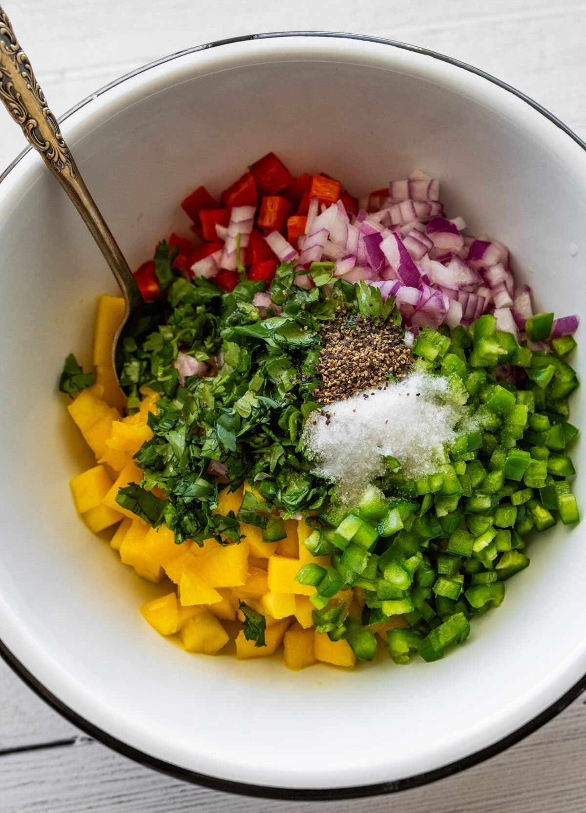 all of the ingredients to make mango salsa in a bowl before combining,