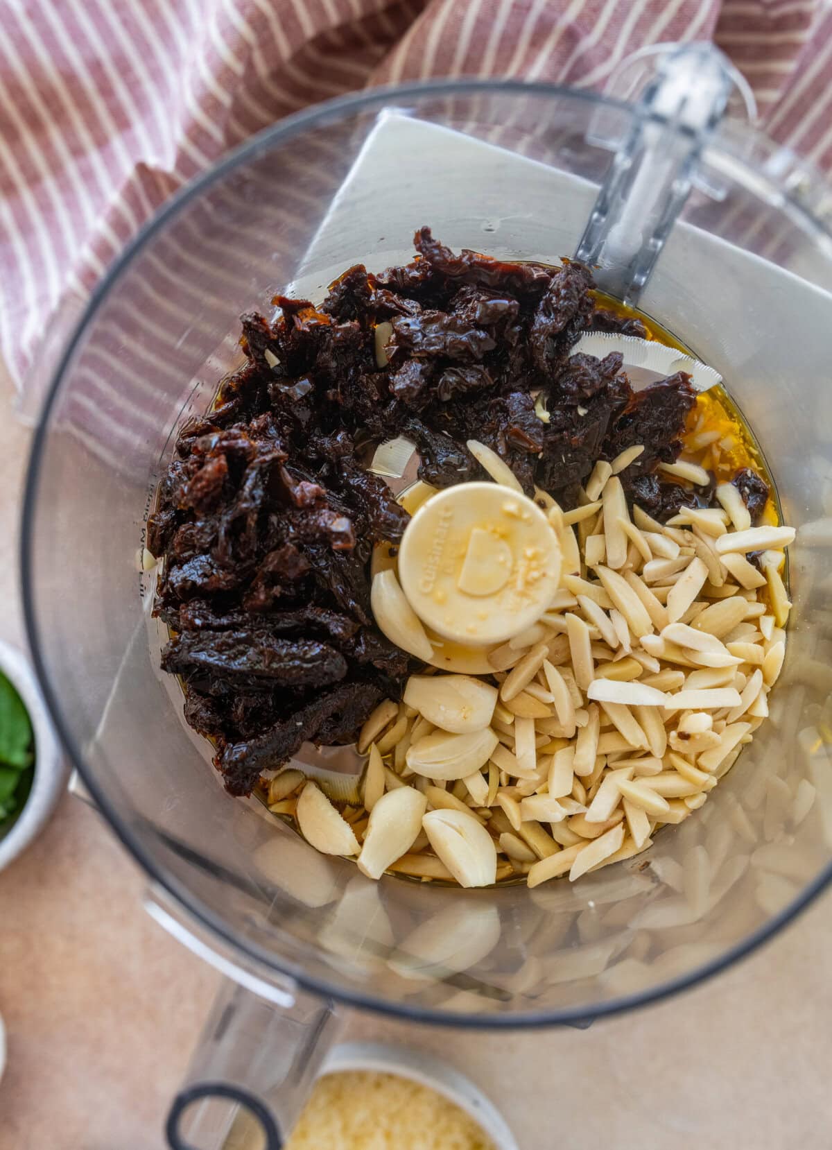 Sun dried tomatoes (with their oil), nuts, and garlic in a food processor.