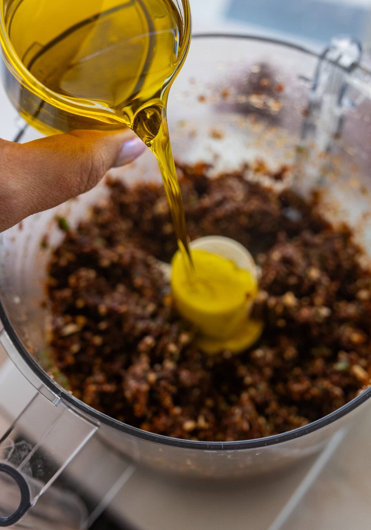 Oil being poured into the food processor.