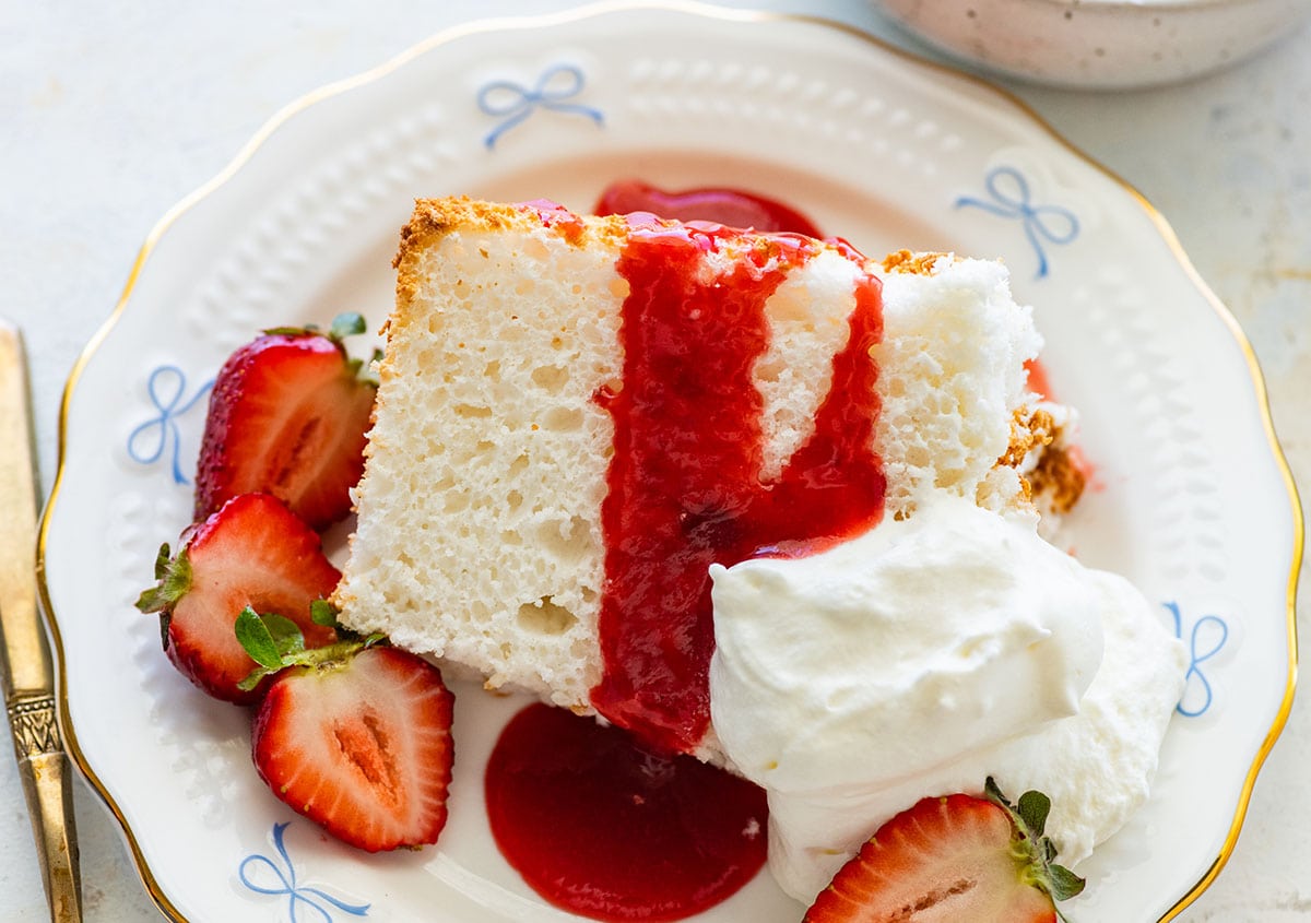 slice of angel food cake with strawberry sauce and fresh strawberries.