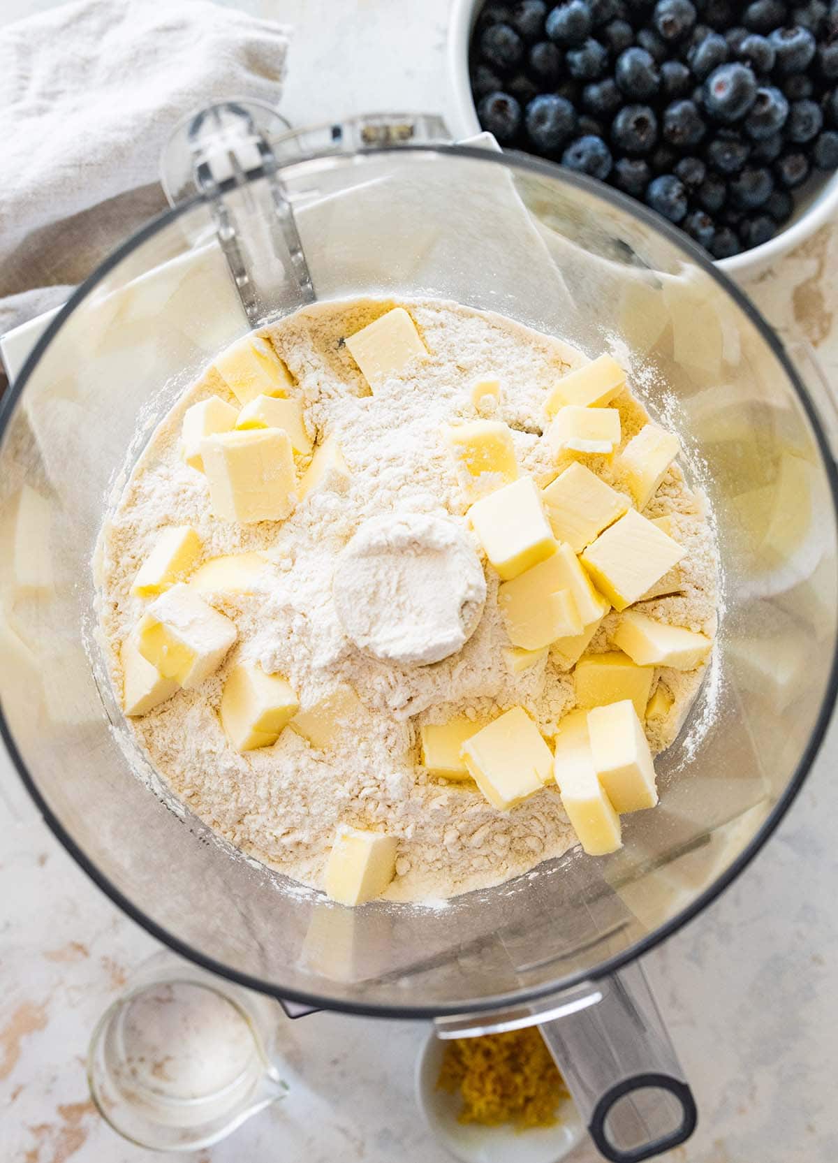 adding butter and flour to a food processor.