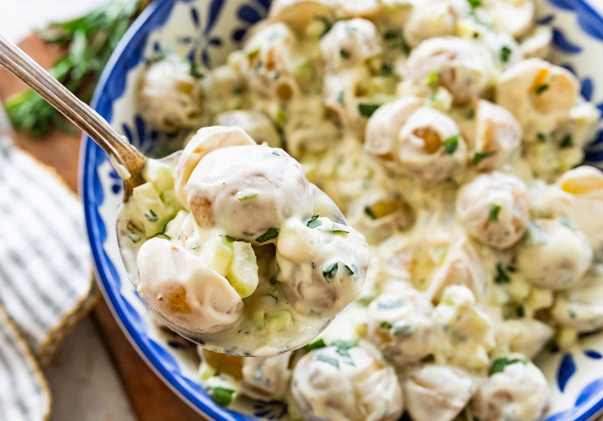 holding a spoonful of creamy potato salad.