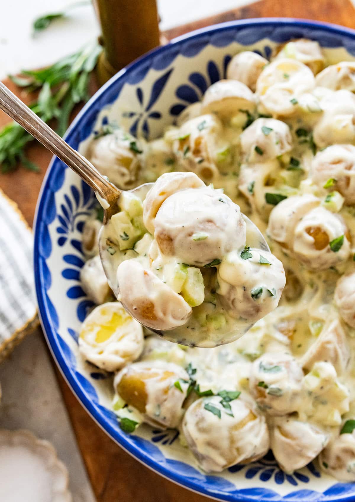 holding a spoonful of creamy potato salad.