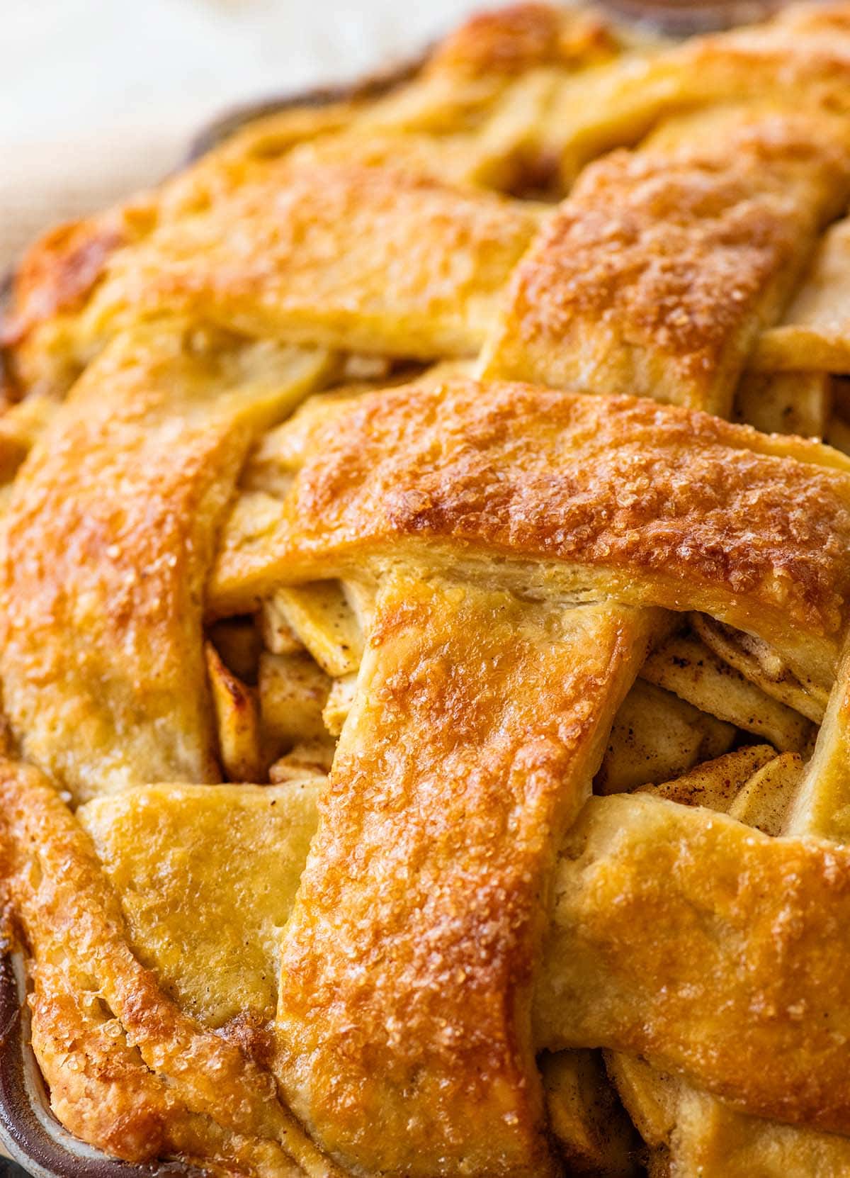 flaky layers in baked pastry lattice on top of an apple pie.