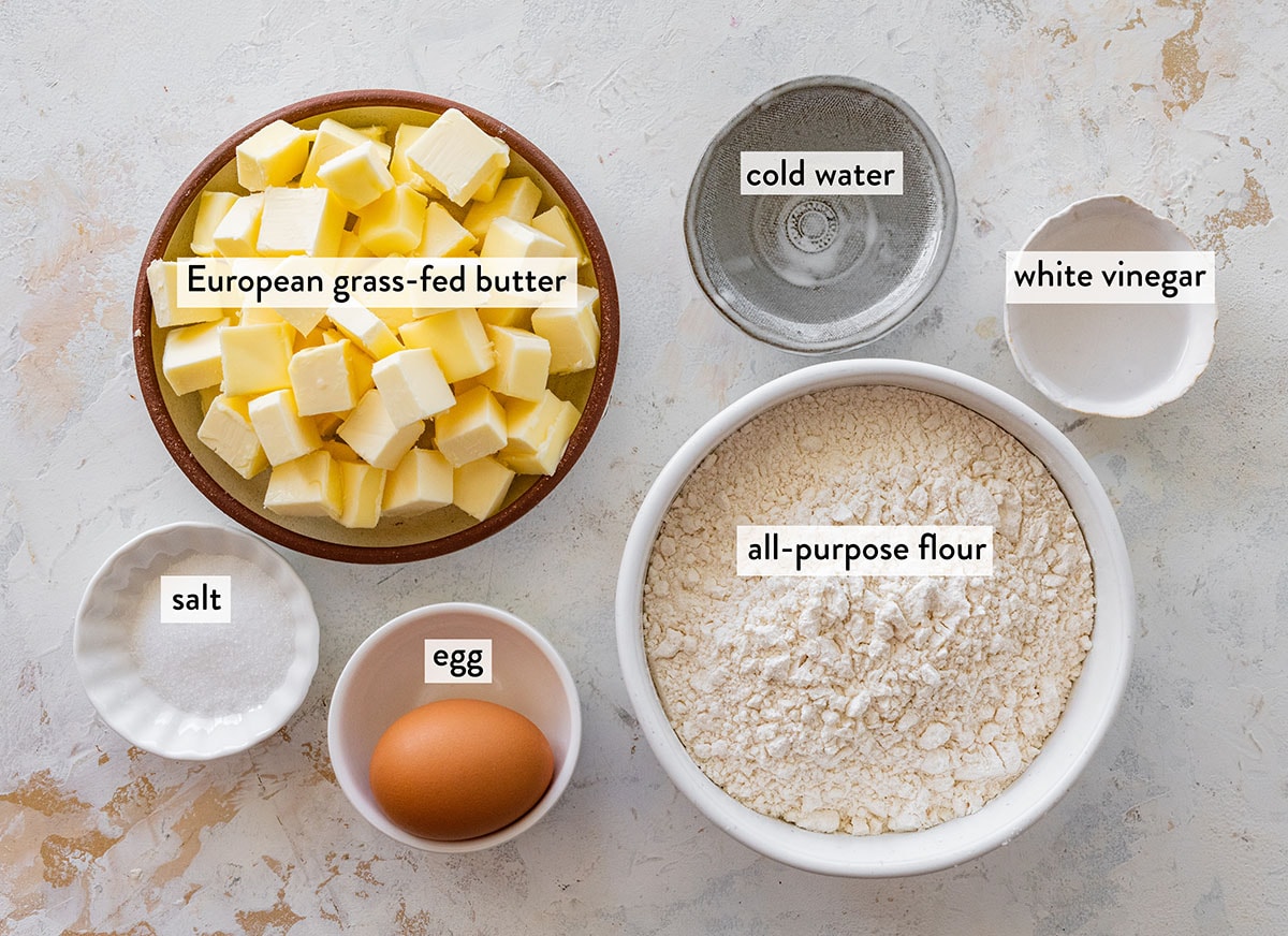 bowls of ingredients for butter pie crust on a distressed white countertop.