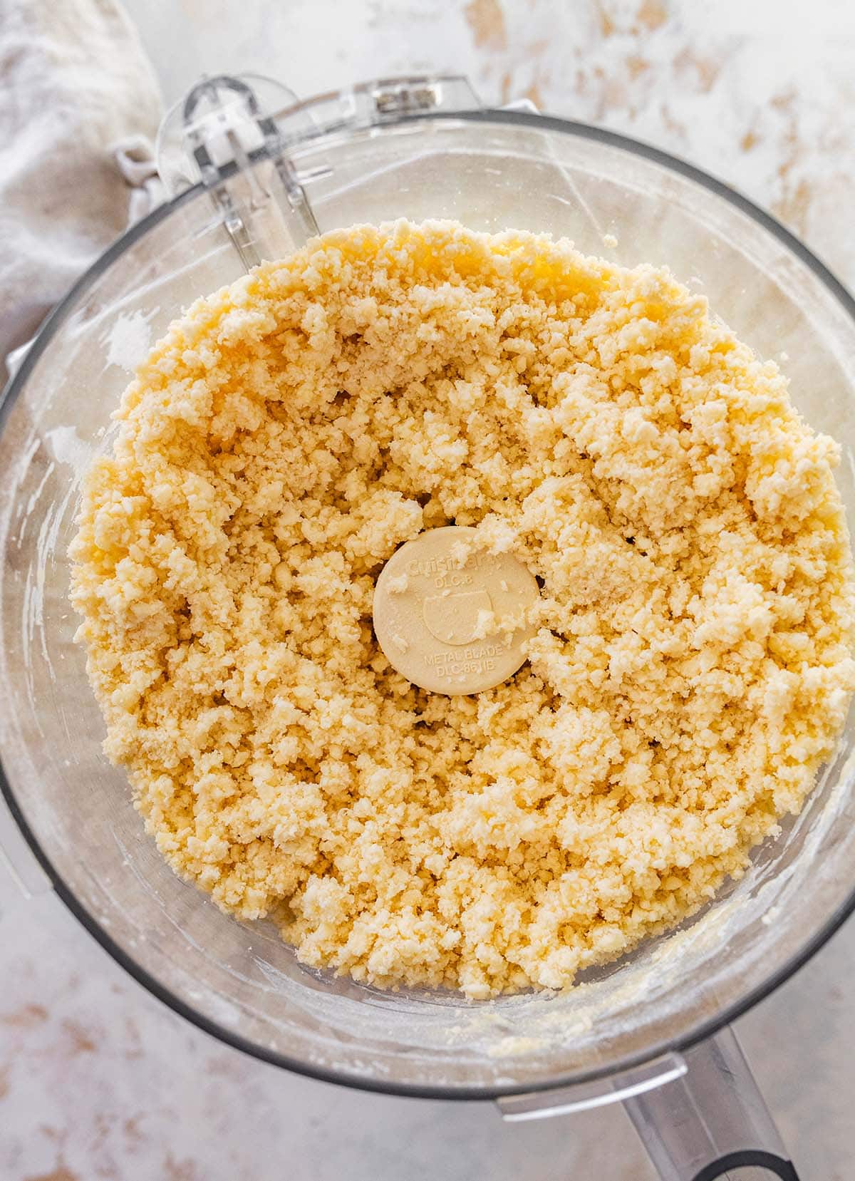 finished pastry in a food processor showing a clumpy but not dry dough.