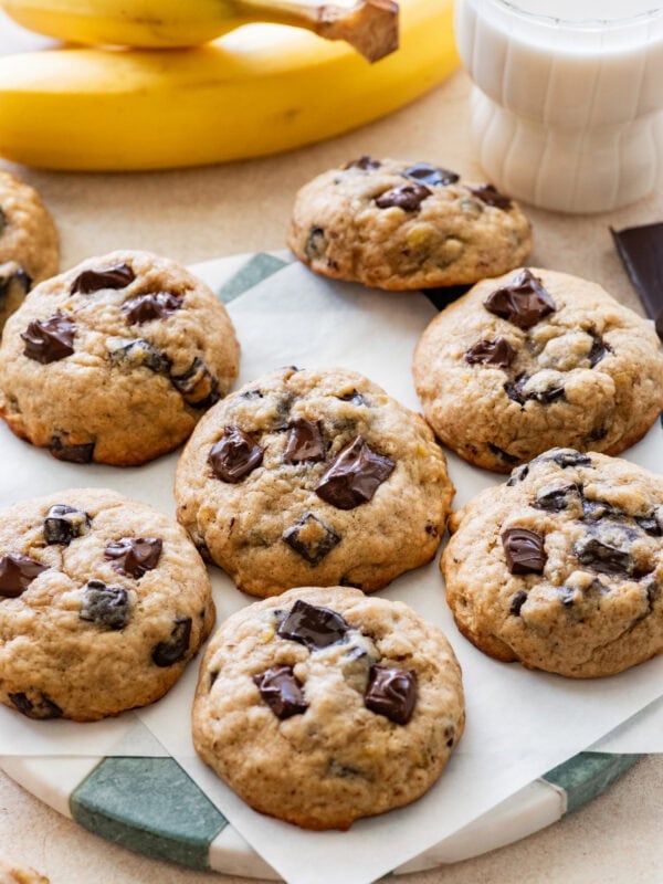 Banana bread cookies on a plate after baking, with more ingredients nearby.