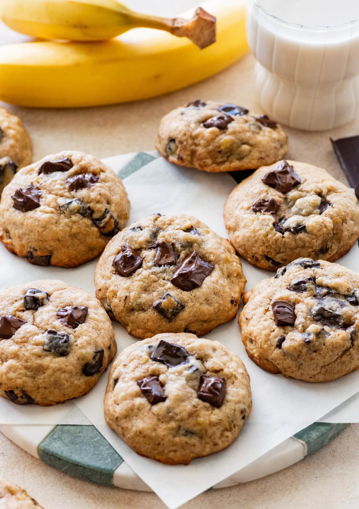 Banana bread cookies on a plate after baking, with more ingredients nearby.