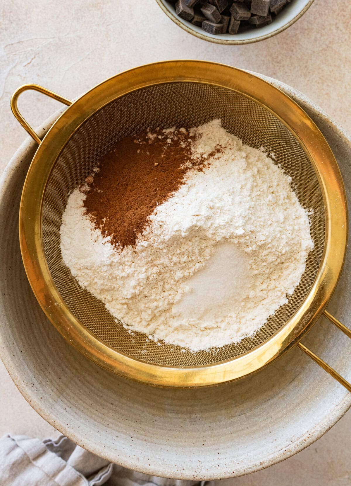 The dry ingredients being sifted into the wet ingredient bowl.