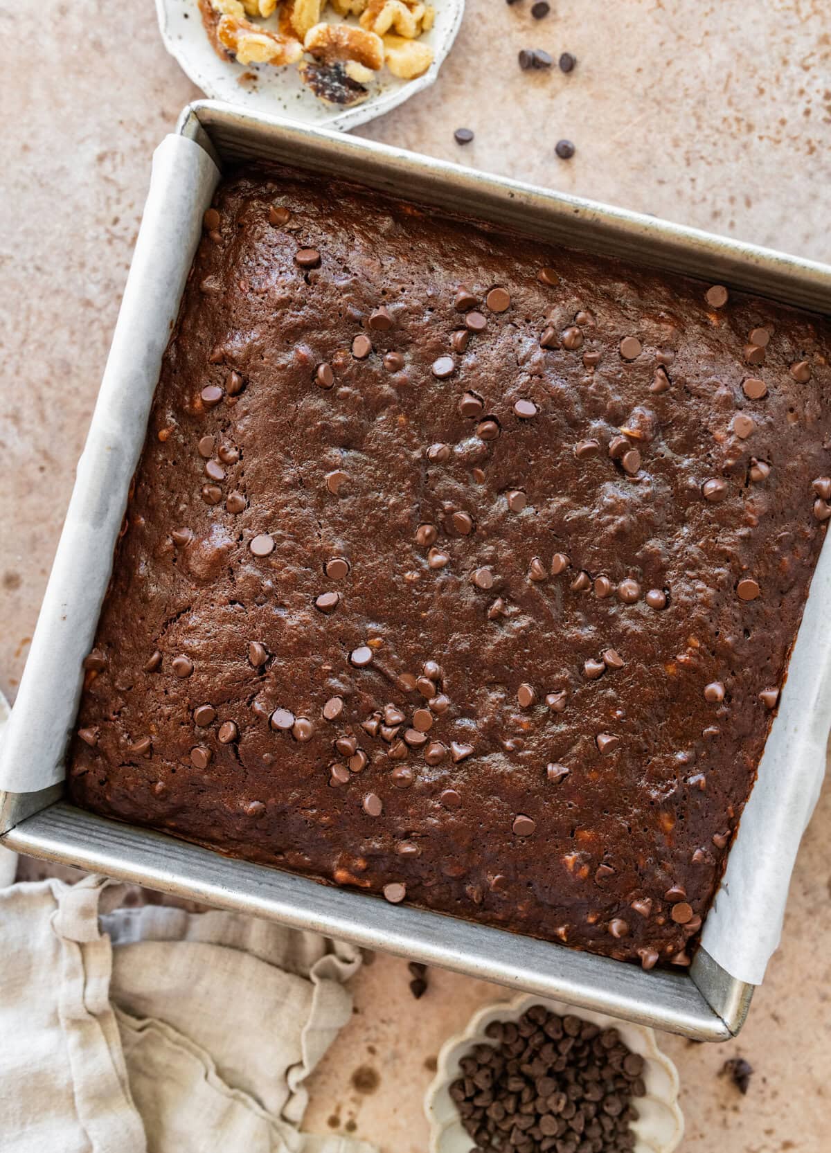 Cooked brownies in a pan with ingredients nearby.