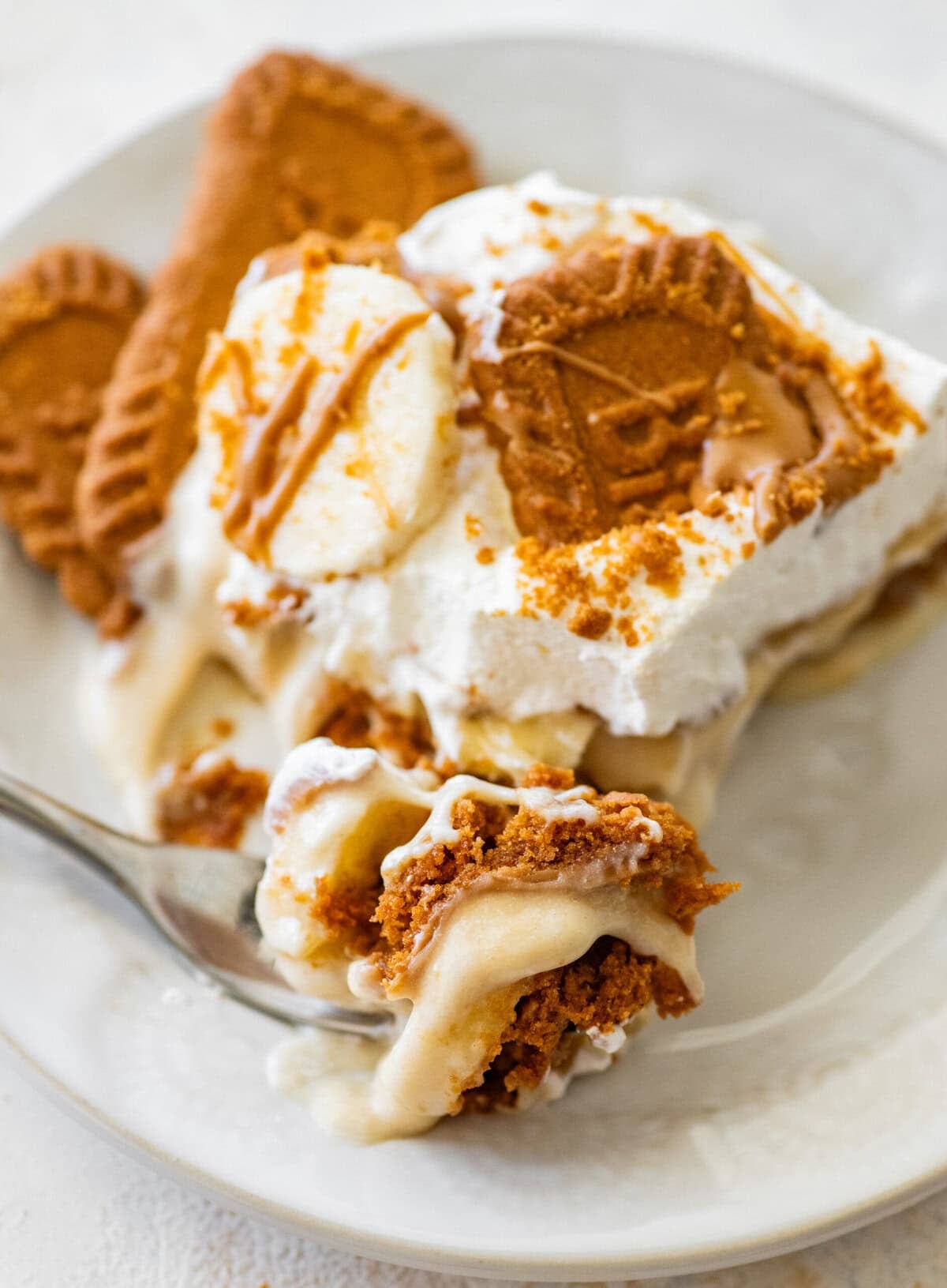 A bite of the pudding on a fork with a plate of more nearby.