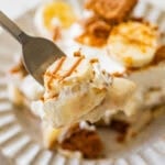 A bite of the pudding on a fork with a plate of more nearby.