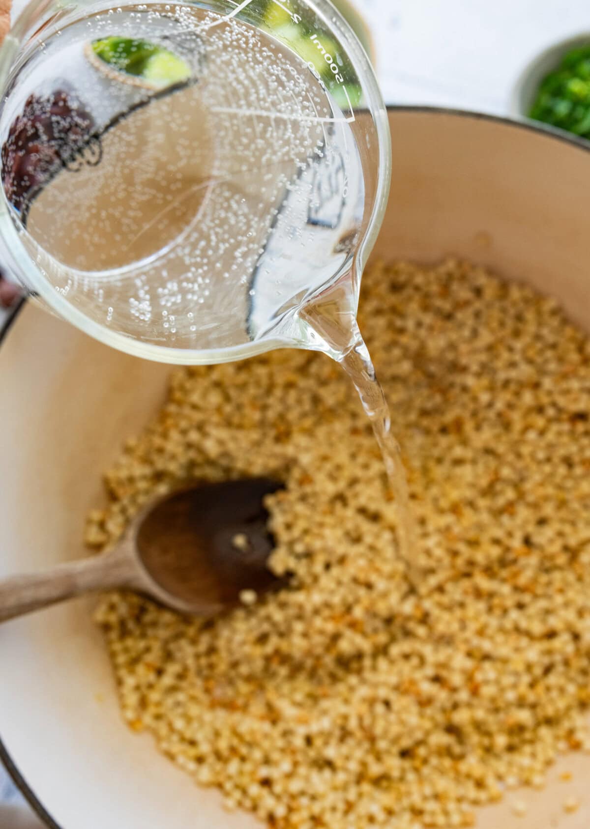 Water being poured into the pot of couscous.