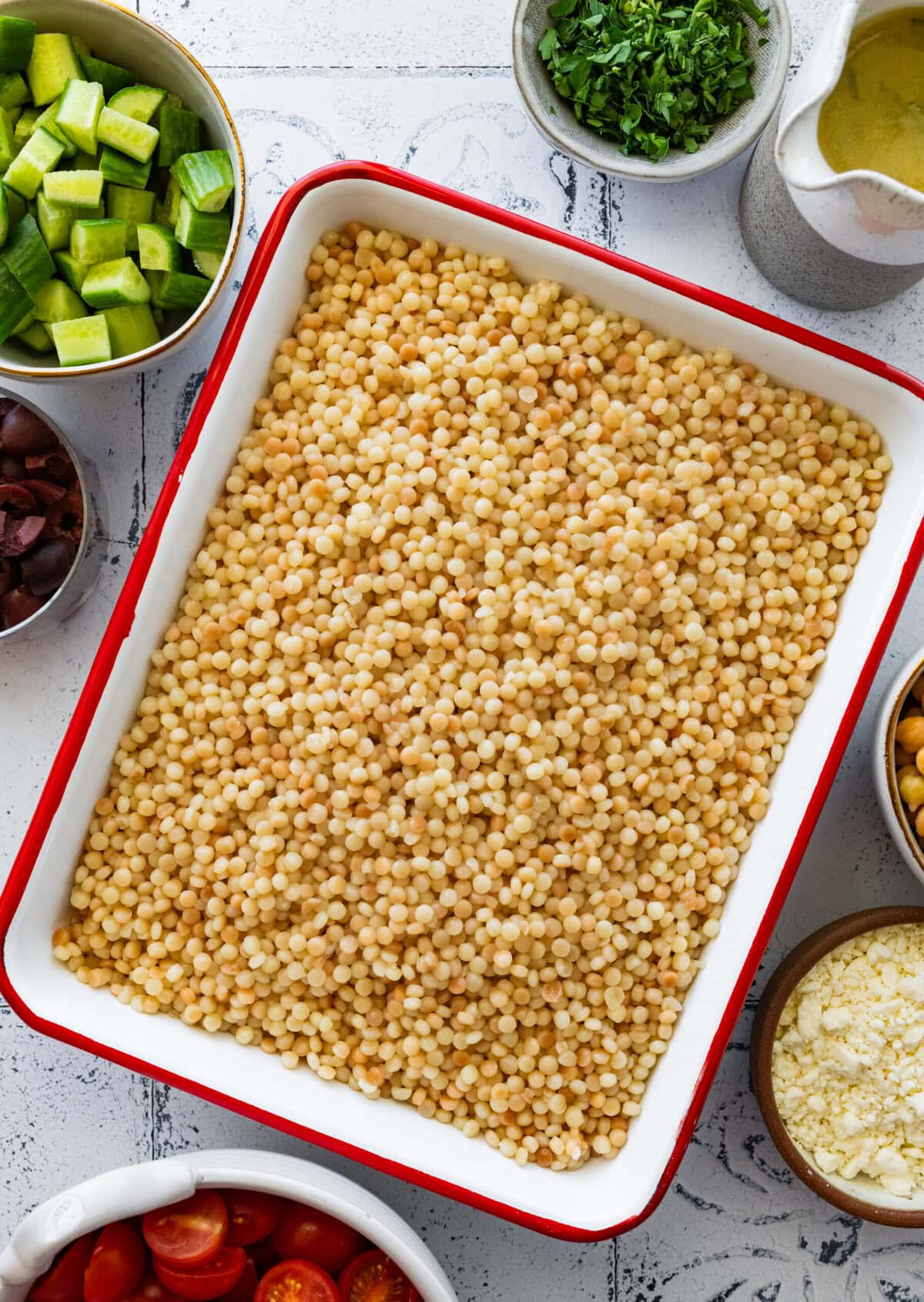 Couscous spread out onto a large dish to cool.