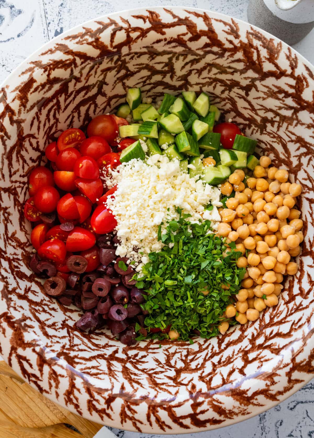 Salad ingredients added to the bowl of cooked couscous.